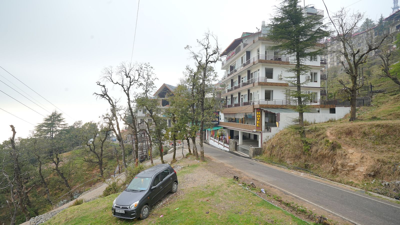 Image of the hotel from a side angle with trees in the background | DLS Hotel Shiva Sanctuary and Spa